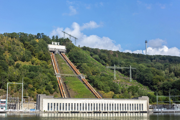 DEU, Deutschland, Koepchenwerk, Herdecke, Pumpspeicherwerk, Industrielles Erbe 29.07.2019 Das Koepchenwerk ist ein national bedeutsames Monument der Energiewirtschaft. Es wurde in den Jahren 1927 bis 1930 errichtet. Seinen Namen trägt es nach seinem Ideengeber und damaligen RWE-Vorstand, Prof. Dr. Arthur Koepchen. Das Koepchenwerk ist eines der beiden ersten Pumpspeicherkraftwerke Deutschlands und im nahezu authentischen technischen wie baulichen Zustand erhalten. Dazu zählen unter anderem die historische Maschinenhalle mit Kommandohaus inklusive der vier originalen Maschinensätze. Sie bestehen jeweils aus Turbine, Motor-Generator, Kupplung und Pumpe. Außerdem gehören dazu die vier markanten Druckrohrleitungen sowie das Schieberhaus mit dem Firmenschriftzug.Die Entwicklung der Pumpspeichertechnik in den 1920er Jahren war eine große Pionierleistung, die den fortschrittlichen Ausbau eines europäischen Verbundnetzes ermöglichte. Nach einem im Dezember 1980 aufgetretenen Schaden und nach ersten Reparaturmaßnahmen war das Koepchenwerk nur bedingt wieder einsatzfähig. 1981 entschied der RWE-Vorstand, dass unmittelbar neben dem Koepchenwerk ein neues und hochmodernes Pumpspeicherkraftwerk entstehen sollte. Dieses wurde zwischen 1985-1989 errichtet und 1989 als Pumpspeicherkraft Herdecke mit 153 Megawatt Leistung in Betrieb genommen. 1994 wurde das Koepchenwerk stillgelegt. Die Voreigentümerin, die RWE Power AG, hat das hochrangige Denkmal im Jahr 2017 in das Eigentum der Stiftung Industriedenkmalpflege und Geschichtskultur übertragen, wodurch es vor dem Abbruch bewahrt werden konnte. [ (c) Markus Bollen / P h o t o - D e s i g n, J o h a n n - B e n d e l - S t r. 16a, 51429 B e r g i s c h G l a d b a c h, fon: 02204 22220, m.bollen@t-online.de ; Kto: IBAN: DE16 6609 0800 0009 1474 38, BIC: GENODE61BBB ; Ust-ID: DE 121 984 724 ; Jegliche Nutzung des Fotos nur gegen Honorar zzgl. der gesetzlichen MwSt., vollstaendiger Namensnennung nach Paragraph 13 UrhG und
